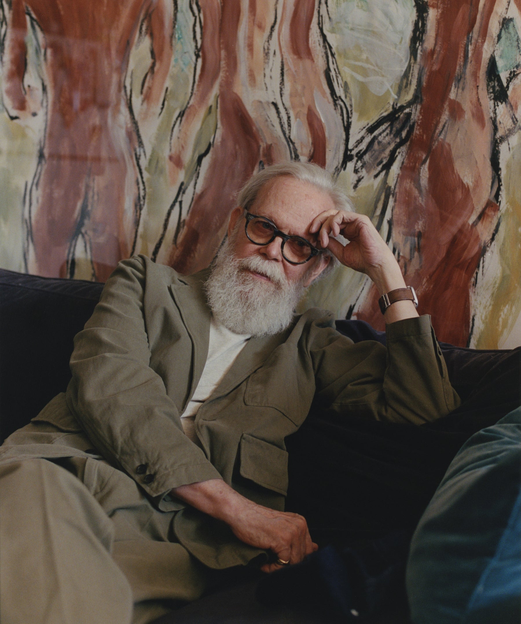 Artist Richard Haines sitting in front of his painting