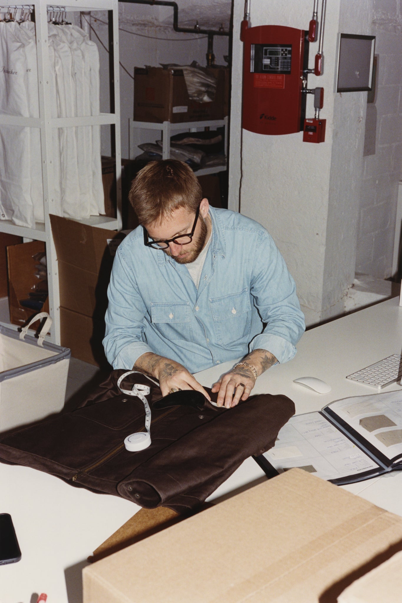 Andrew Livingston measuring a sample jacket at his desk