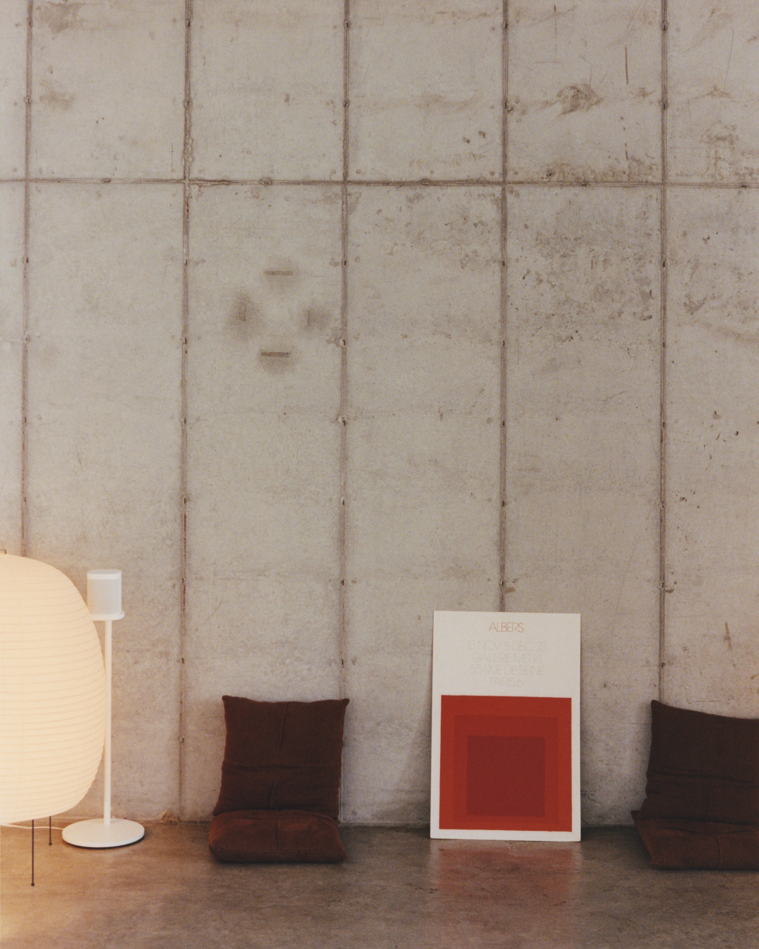 Modern interior with a textured wall, lamp, and abstract painting.