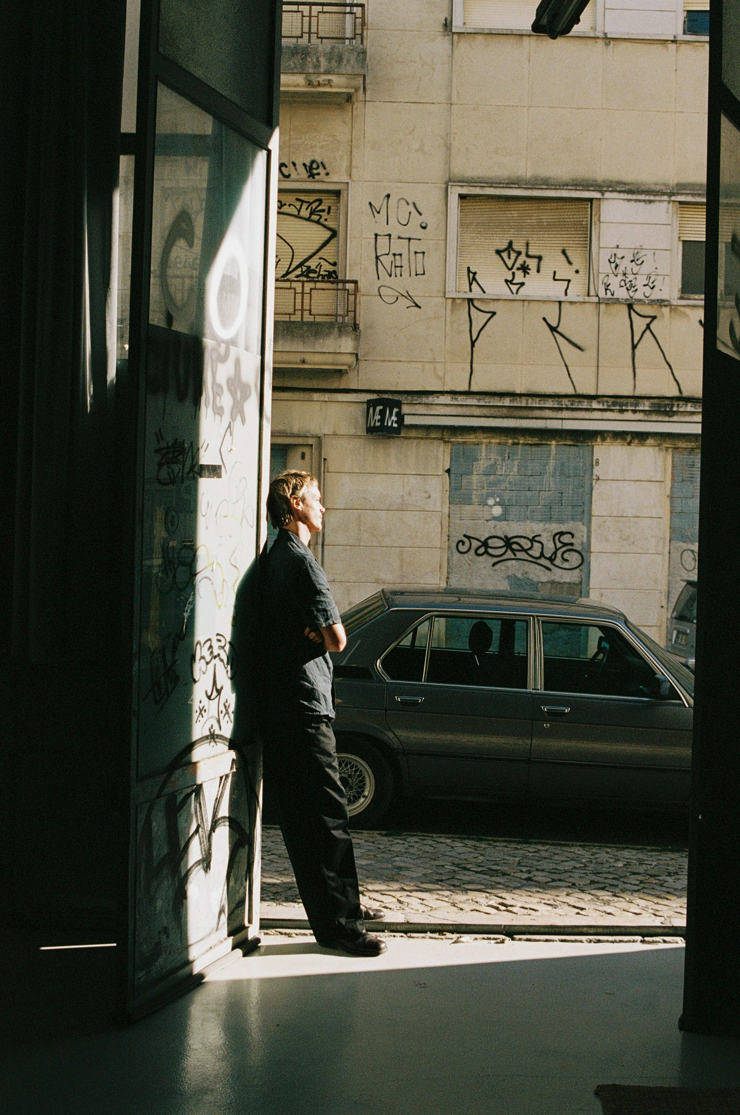 Guy standing by door to street.