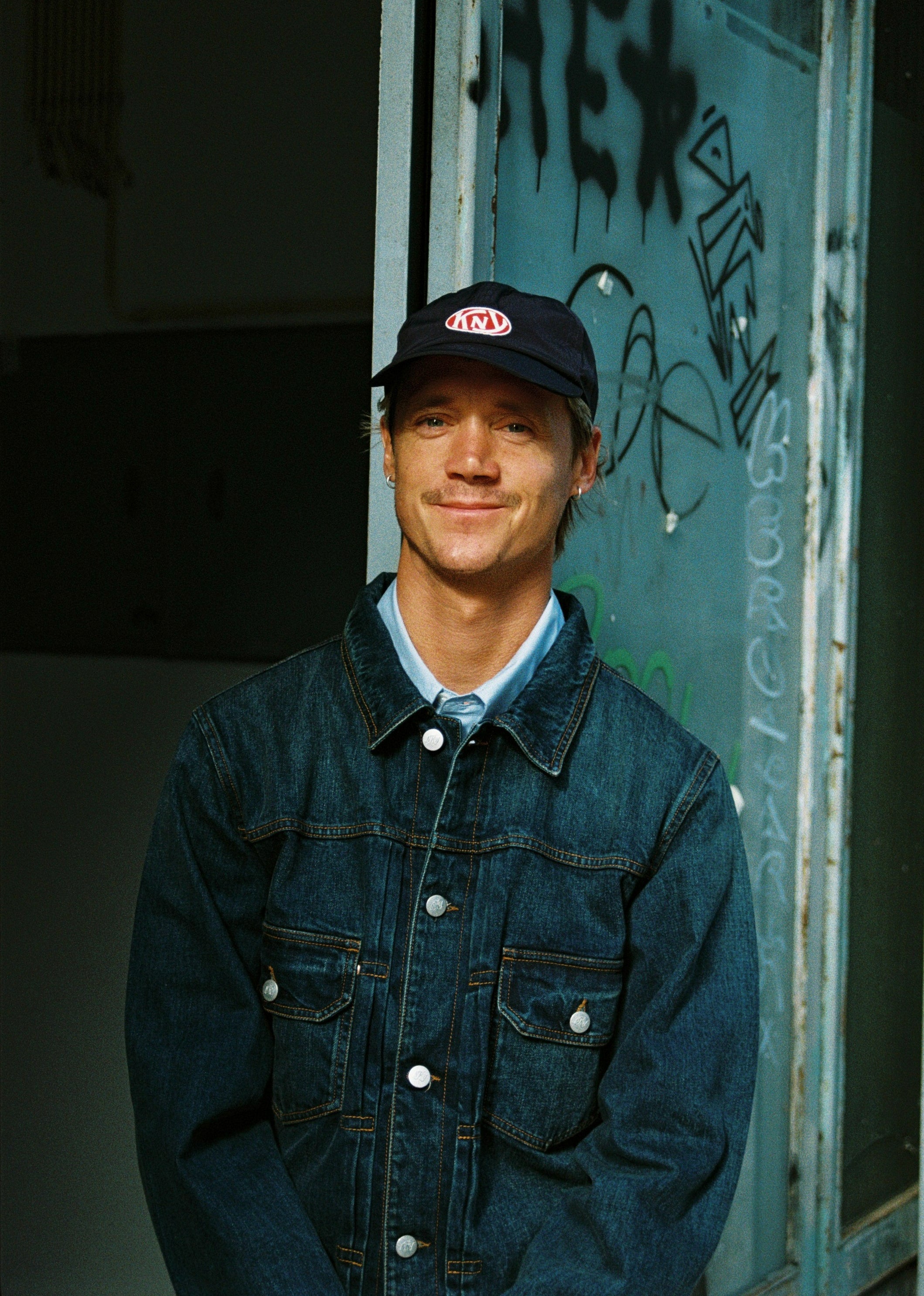 Guy wearing Knickerbocker Denim Jacket and Blue Cap.