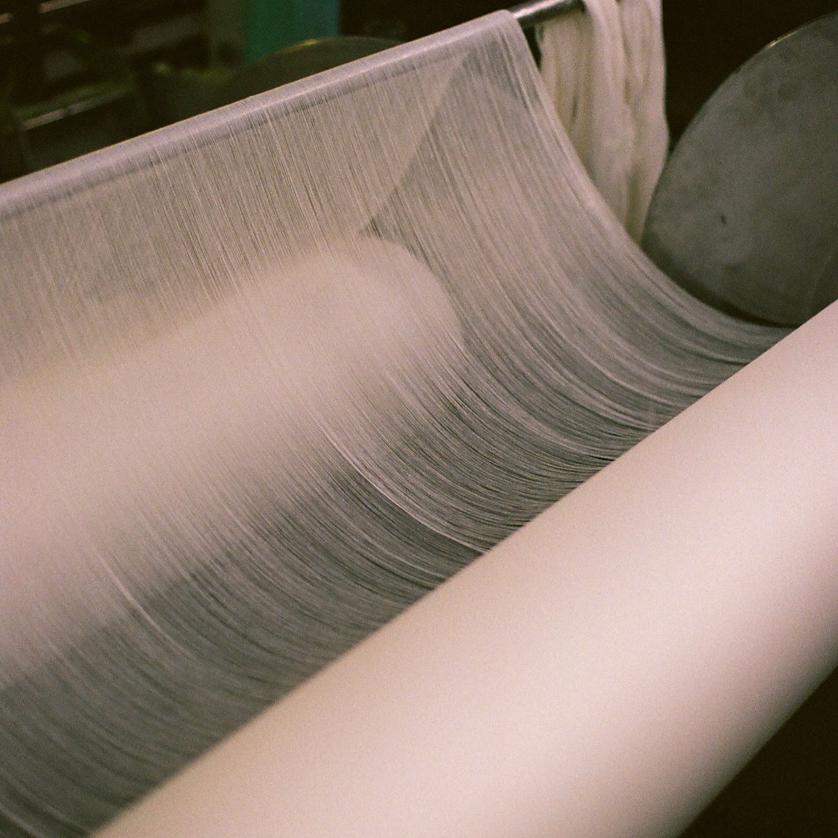 Close-up of a textile manufacturing process with yarn and fabric.