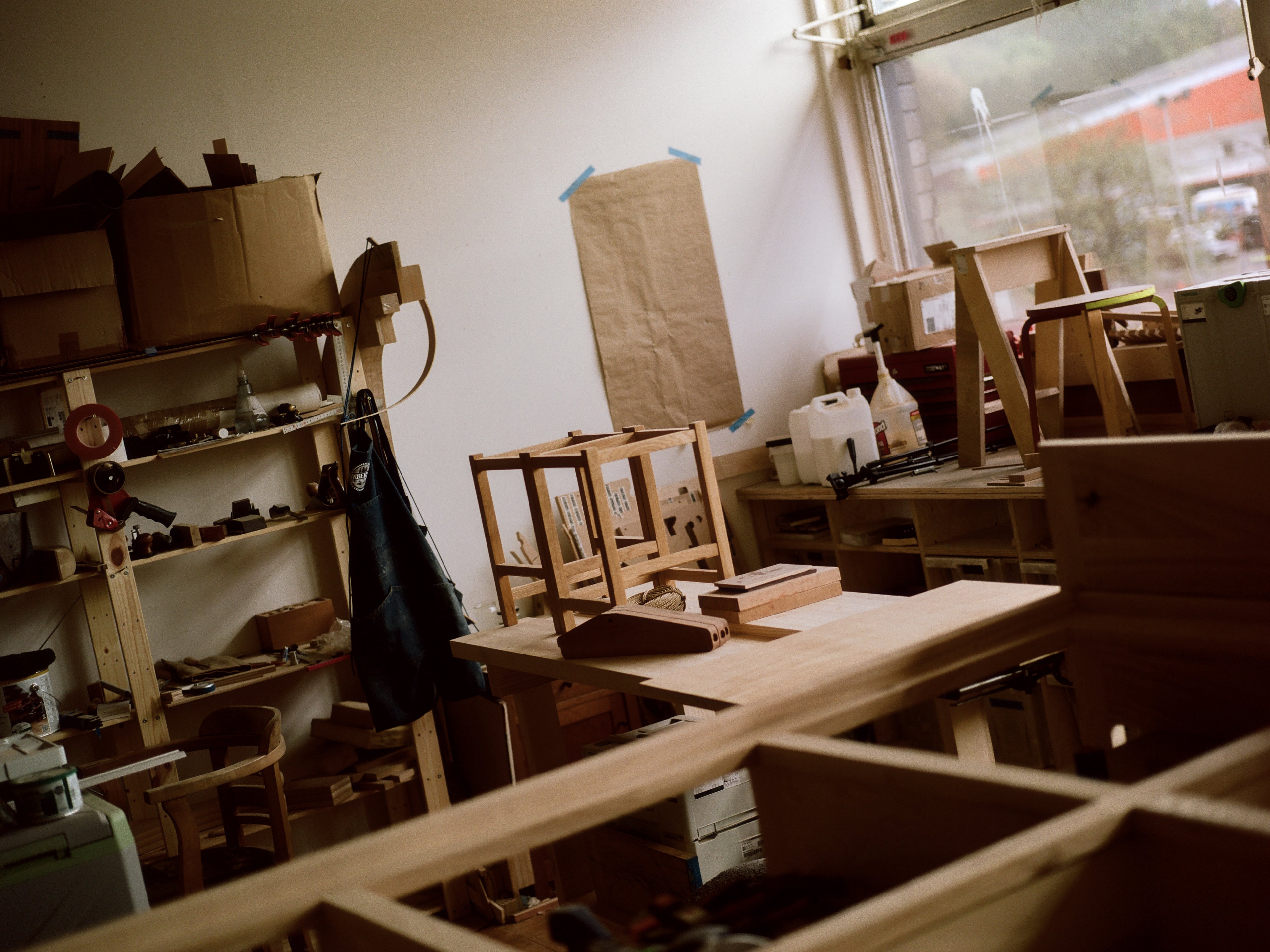 Photo of Neal Cameron's workshop and the wooden stools he's working on. 